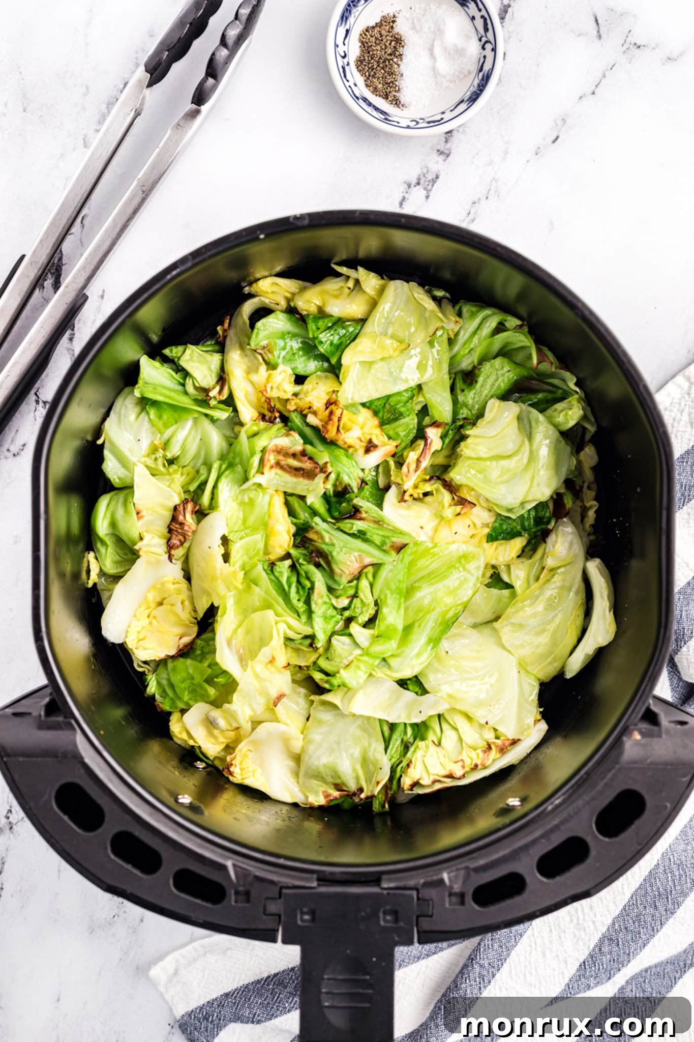 Perfectly cooked, golden-brown air fryer cabbage resting in the air fryer basket, steam gently rising.