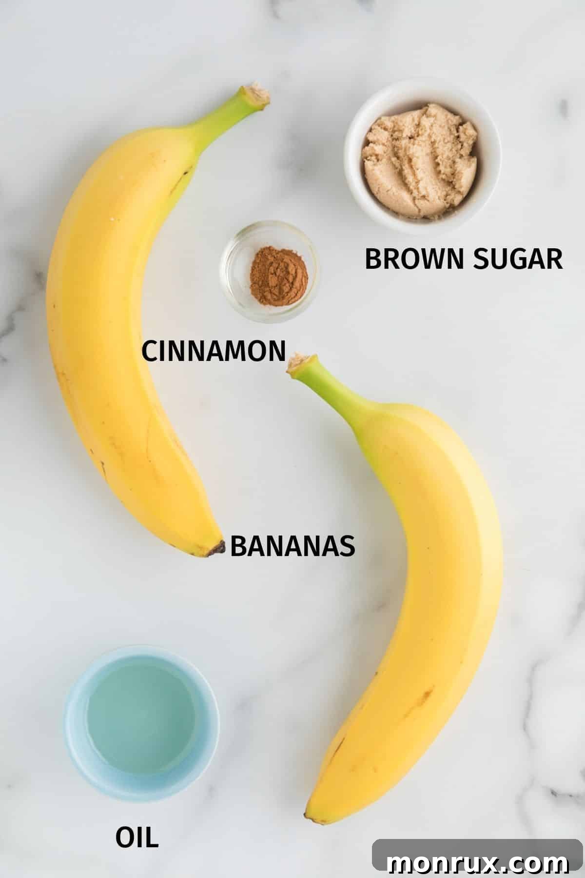 Bananas, brown sugar, cinnamon, and olive oil in bowls on a white surface, showcasing the simple ingredients.
