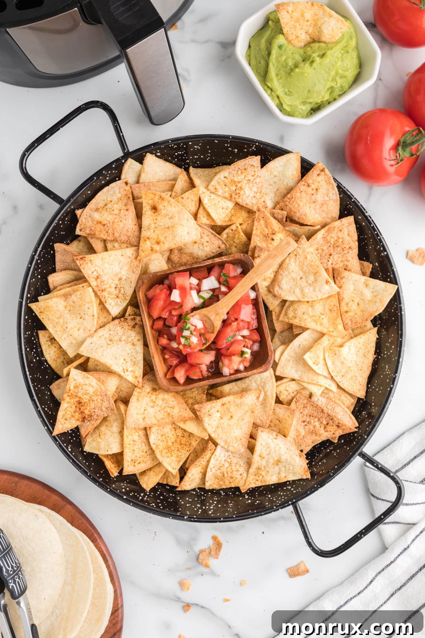air fried corn tortilla chips on platter with salsa.