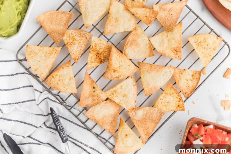 Tortilla chips on a metal cooling rack over a white surface.