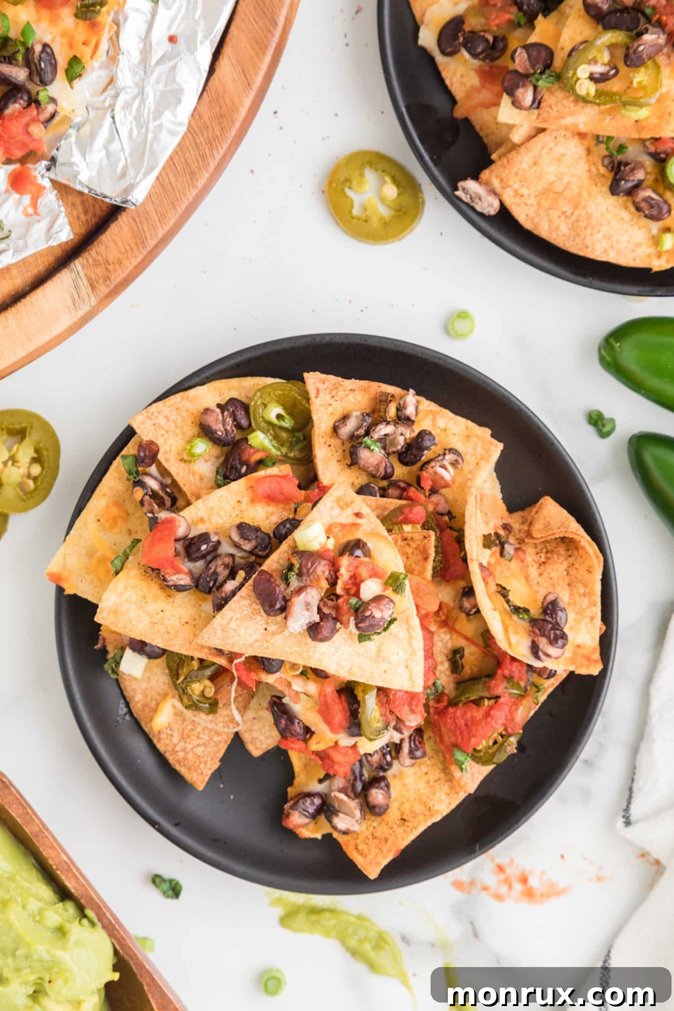 Air fried nachos with black beans and salsa on a plate, garnished with fresh cilantro.