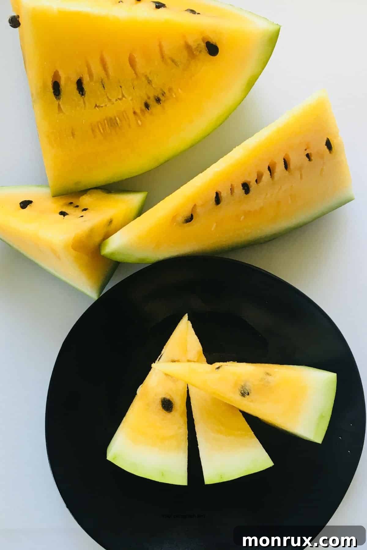 Yellow watermelon cut into pieces on a plate. 