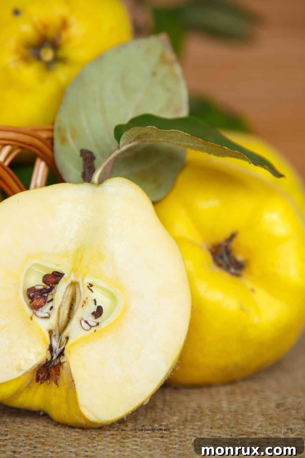Quince fruit cut in half with whole fruit behind it.