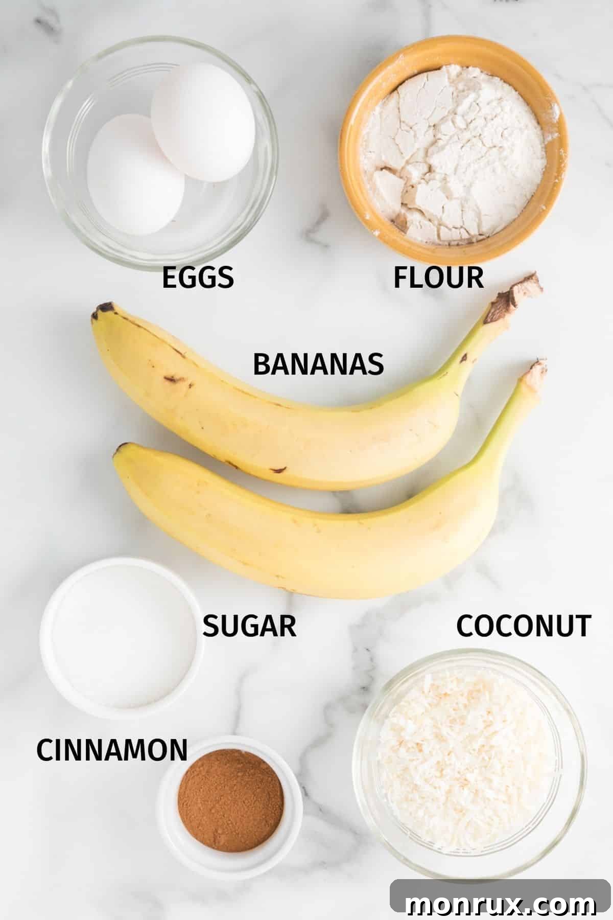 A vibrant display of ingredients for coconut banana fritters, neatly arranged in small, inviting bowls on a pristine white surface, ready for culinary creation.