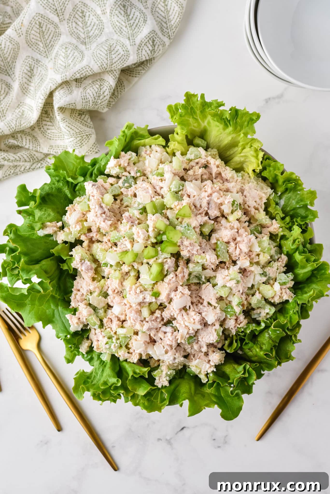 A large serving bowl overflowing with fresh green lettuce, generously topped with homemade Costco-style chicken salad, ready to be enjoyed.