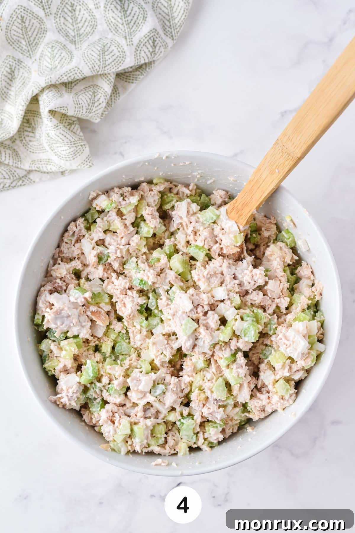 A large bowl brimming with freshly prepared Costco-style chicken salad, perfectly mixed and ready for serving, showcasing its creamy texture and vibrant ingredients.