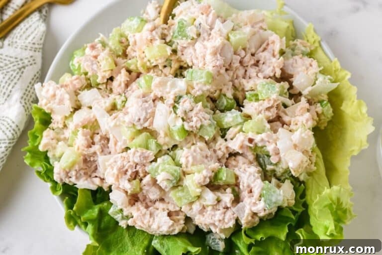 A bowl of delectable Costco-style chicken salad served on a bed of fresh lettuce, ready to be enjoyed.