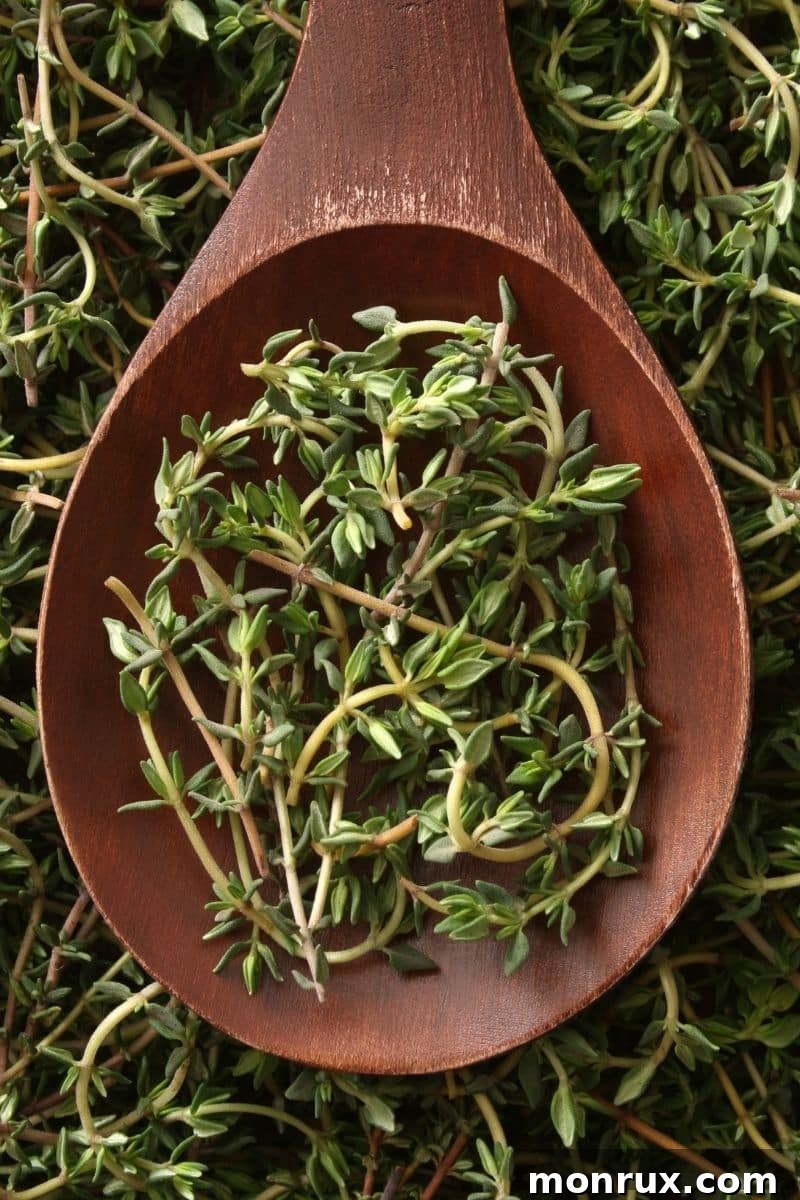 Fresh thyme sprigs on a wooden spoon, ready for use.