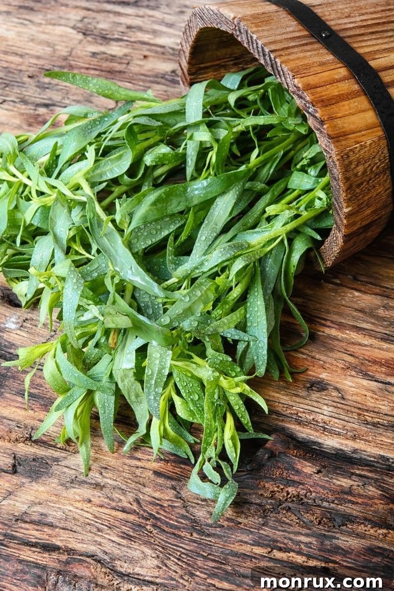 Fresh tarragon sprigs in a wooden bowl.