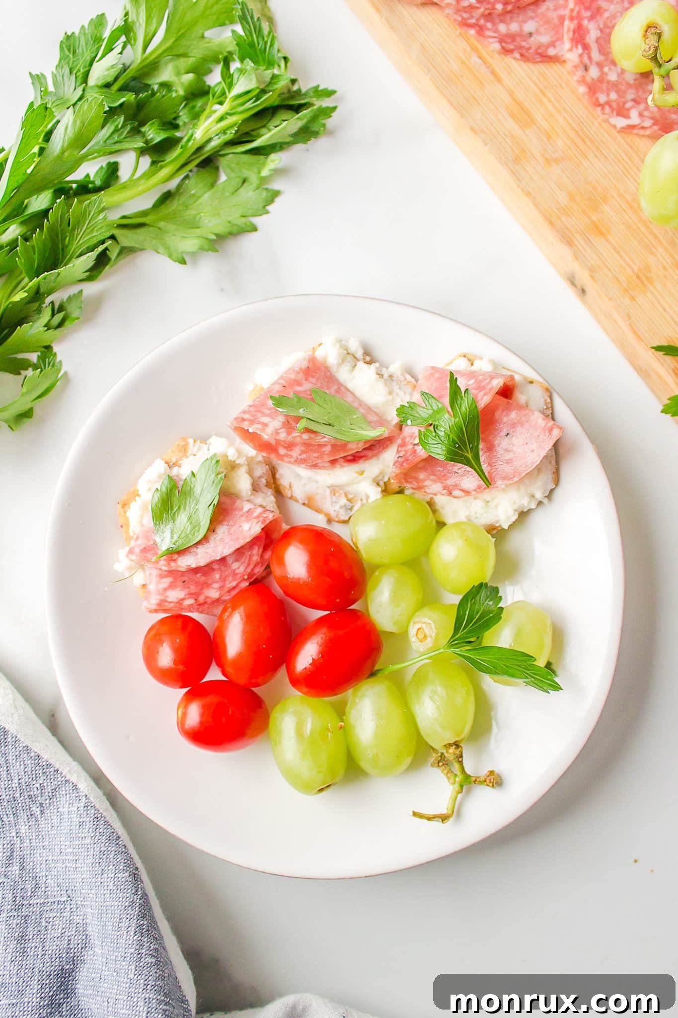 A small white plate showcasing a perfectly portioned selection of dairy-free and gluten-free charcuterie items, ready for individual enjoyment.