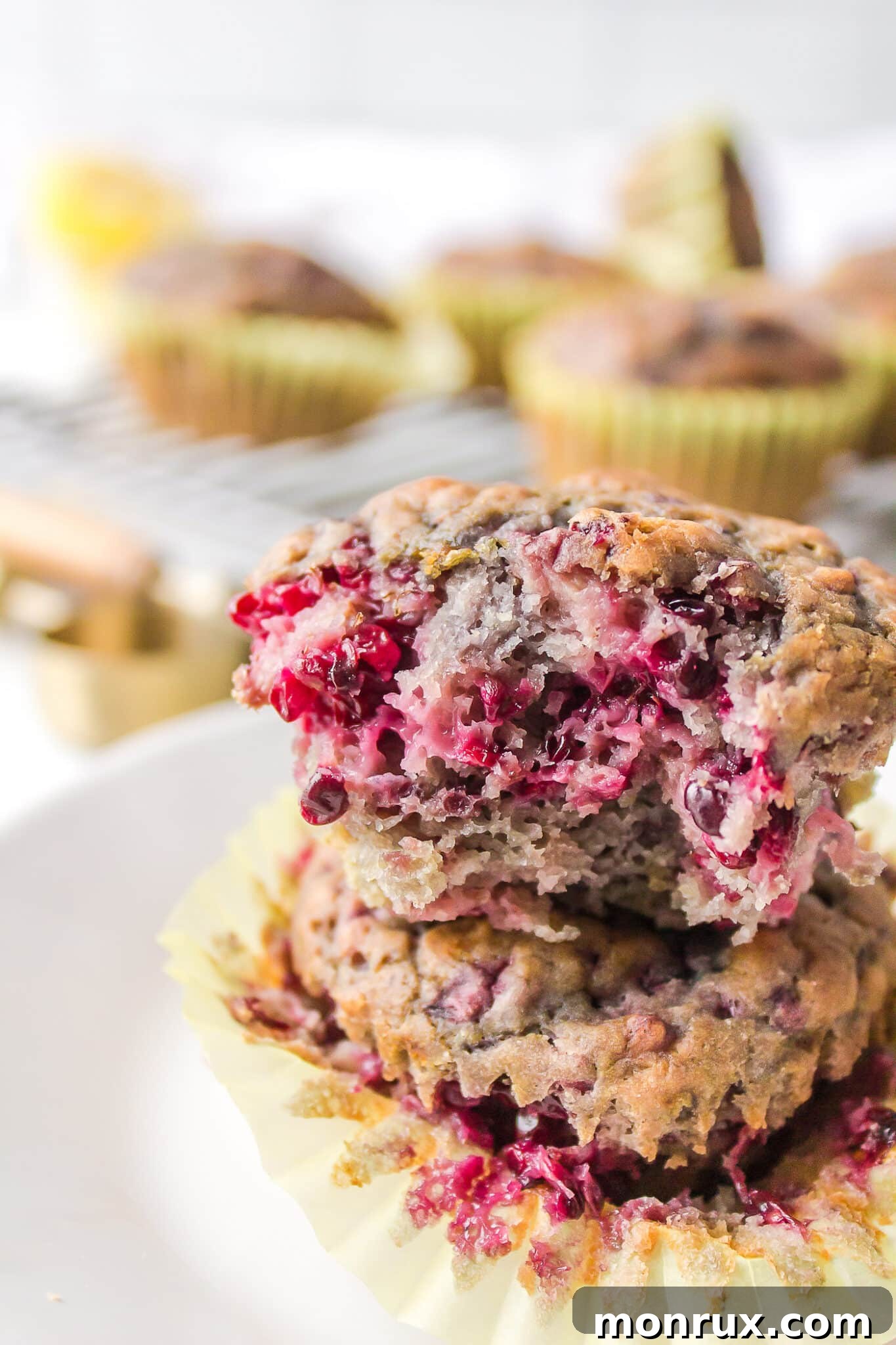 vegan blackberry muffins stacked on each other with a bite taken from one.