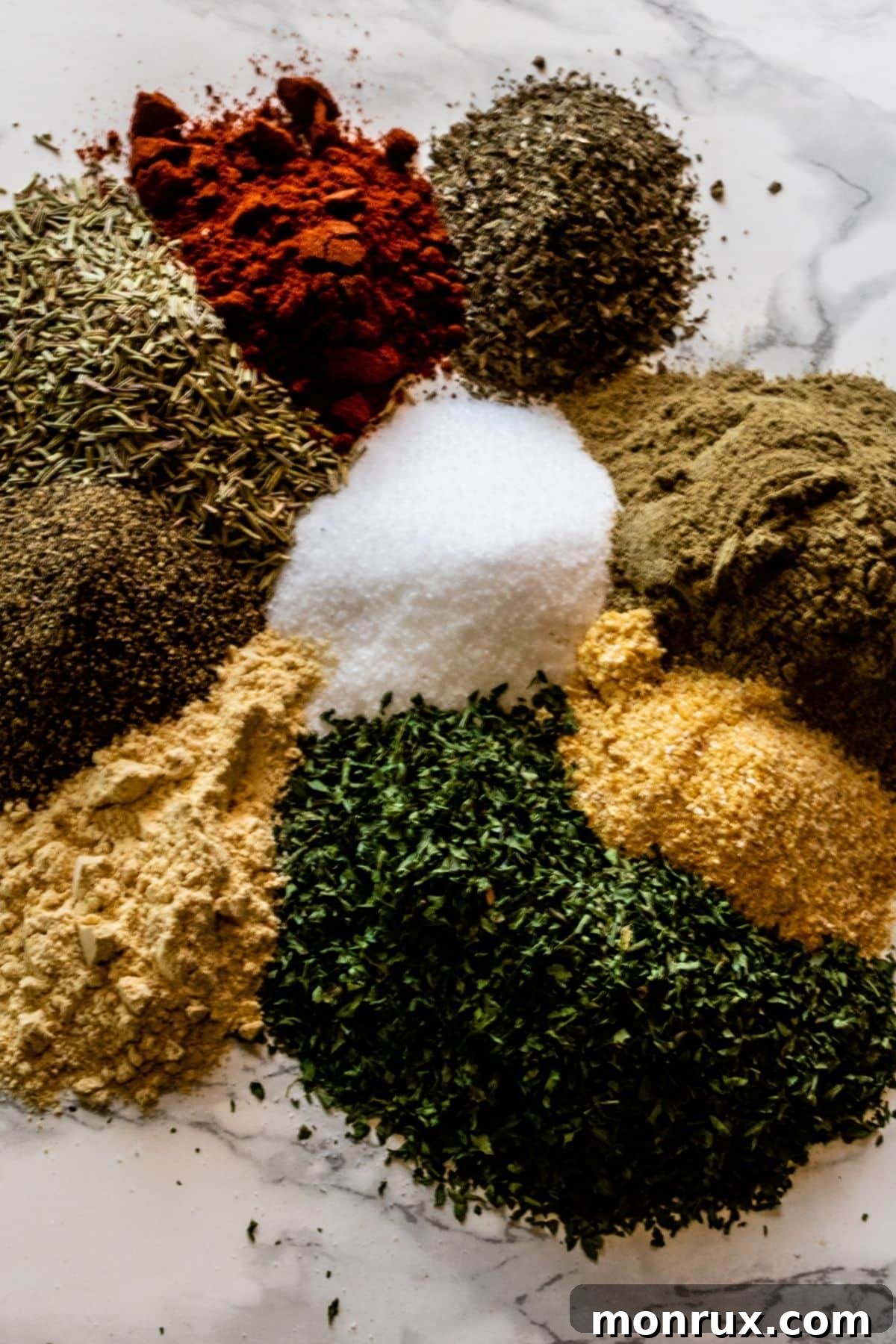 Poultry seasoning in a pile on a white marble surface.