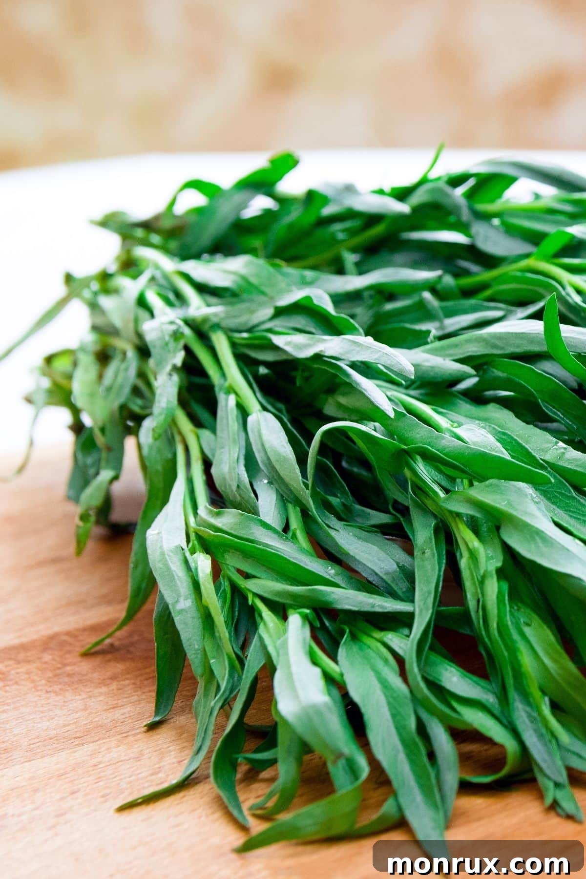 Fresh tarragon sprigs on a wooden surface.