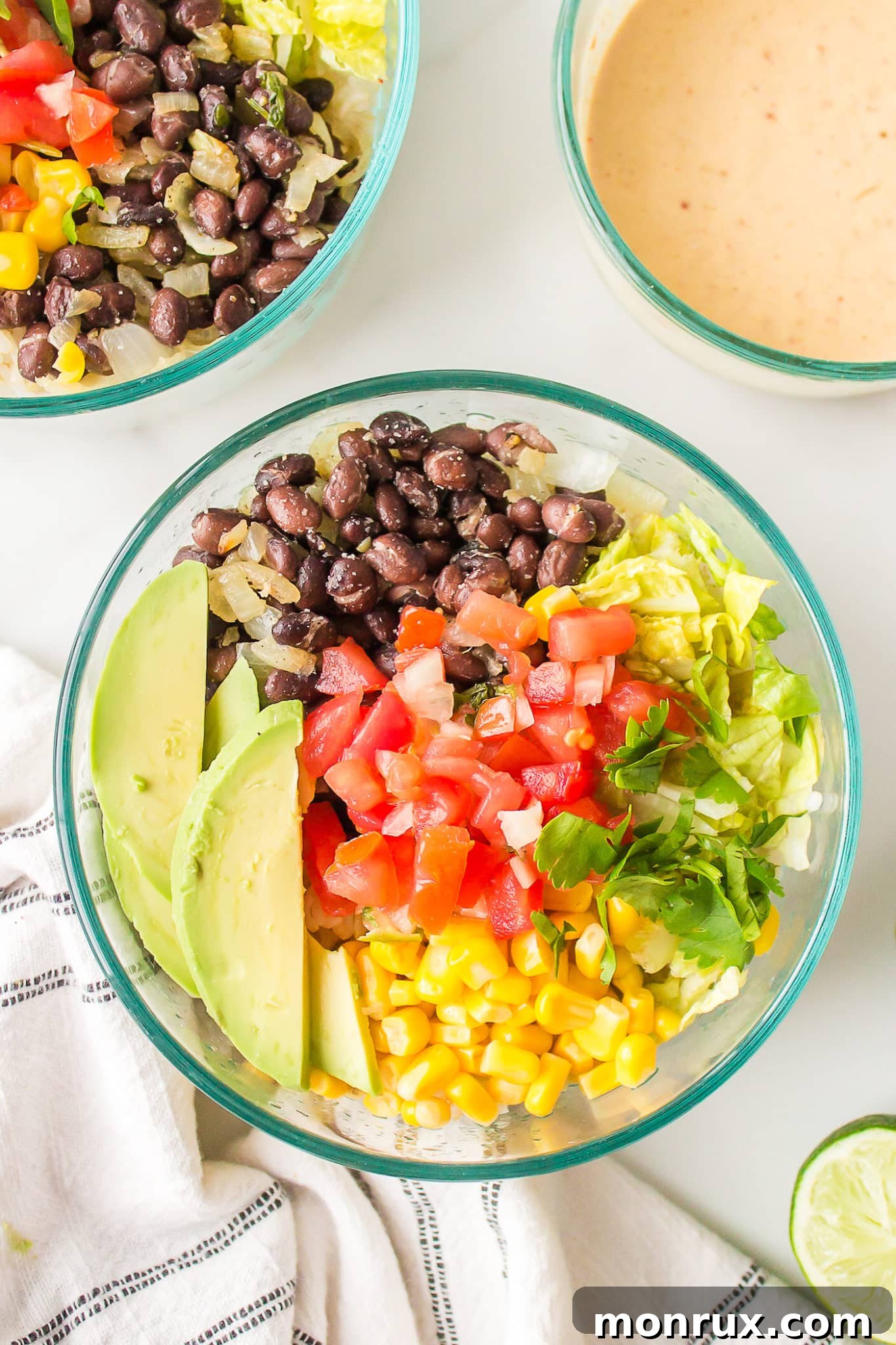 A perfectly assembled Mexican brown rice Buddha bowl in a clear glass, ready to be enjoyed.