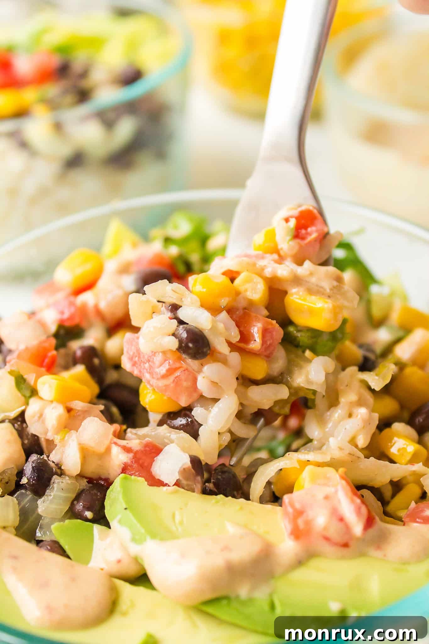 Another enticing view of a healthy Mexican brown rice Buddha bowl in a clear glass, highlighting its fresh and colorful ingredients.