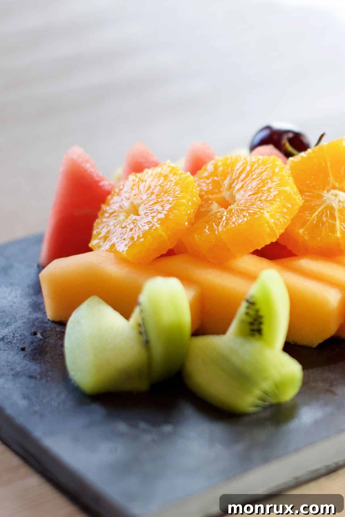 Sliced fruit on a slate platter.