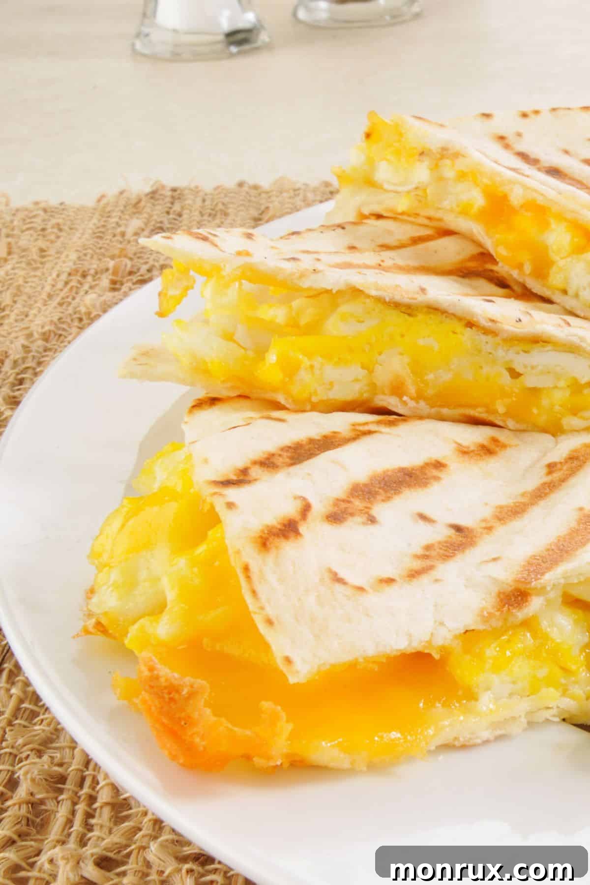 Egg and cheese breakfast quesadilla slices on a plate.