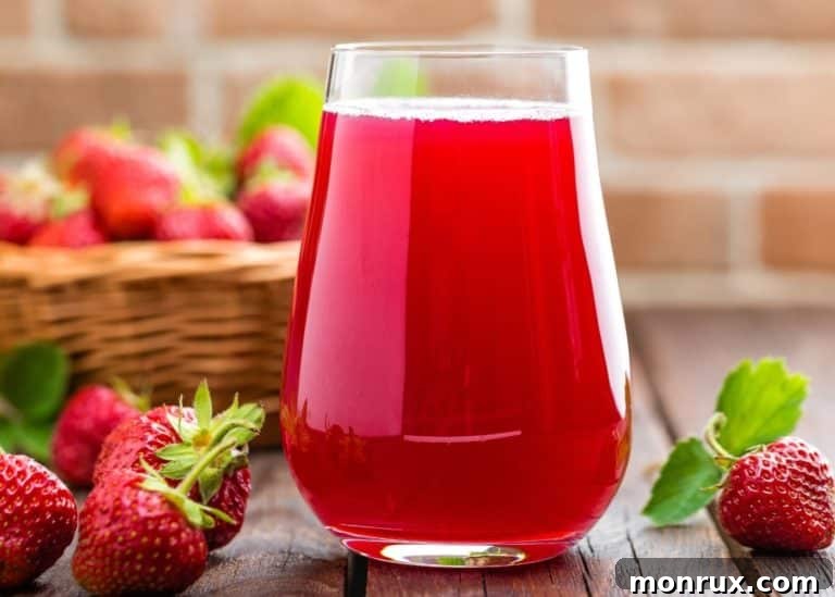 A beautiful glass of homemade strawberry juice, topped with a delicate foam, showcasing its fresh and natural appeal.