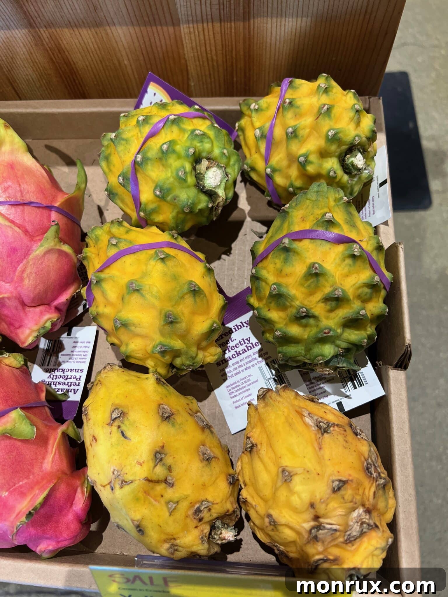 A vibrant selection of yellow dragon fruit displayed for sale in a bustling market stall, highlighting their distinctive golden skin and enticing allure.