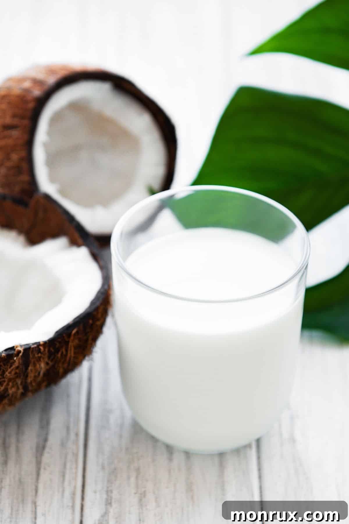 Fresh coconut milk in a clear glass, with a subtle white hue.