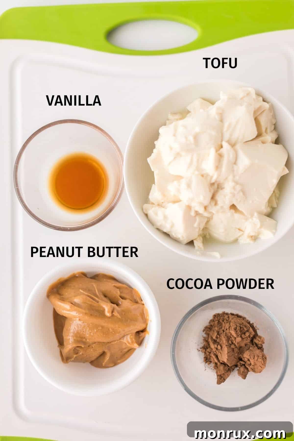 A vibrant display of key ingredients laid out for the vegan peanut butter pie filling, including silken tofu, maple syrup, vanilla extract, cocoa powder, and natural peanut butter.