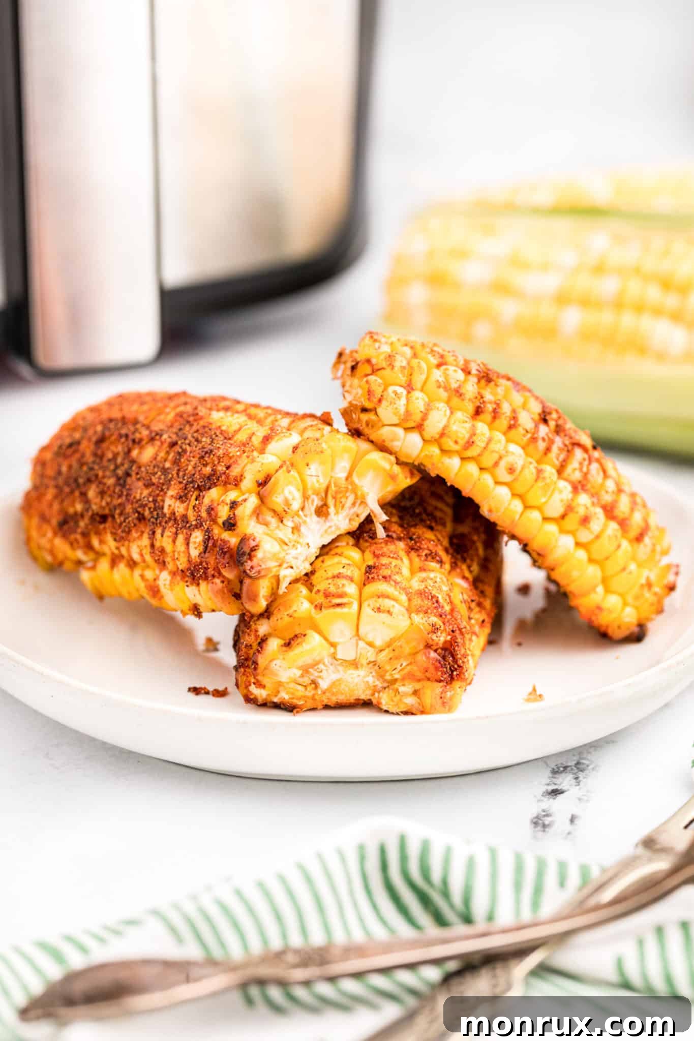 Seasoned air fryer corn ribs on a white plate, ready to be served and enjoyed.