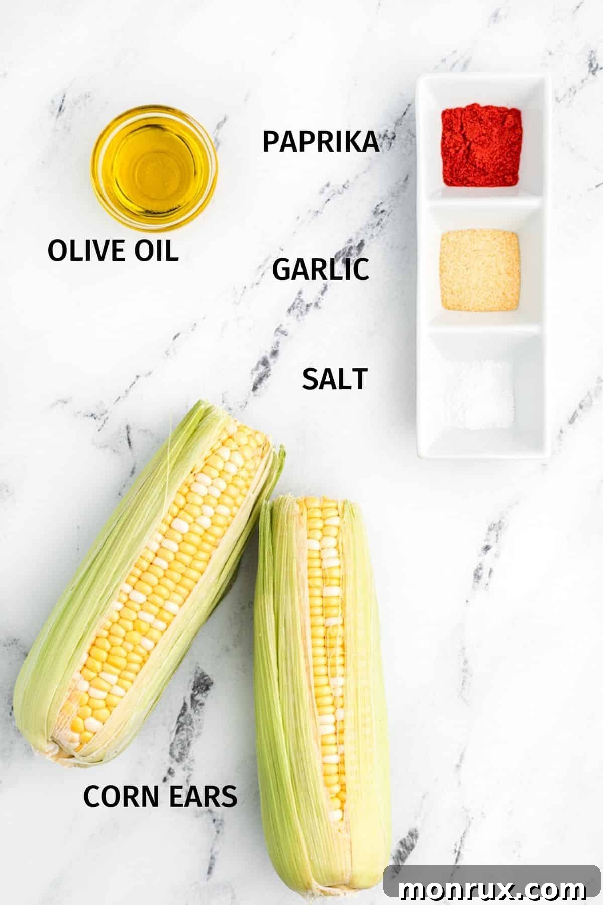 Ingredients laid out for making air fryer corn ribs: fresh corn, olive oil, and various spices.