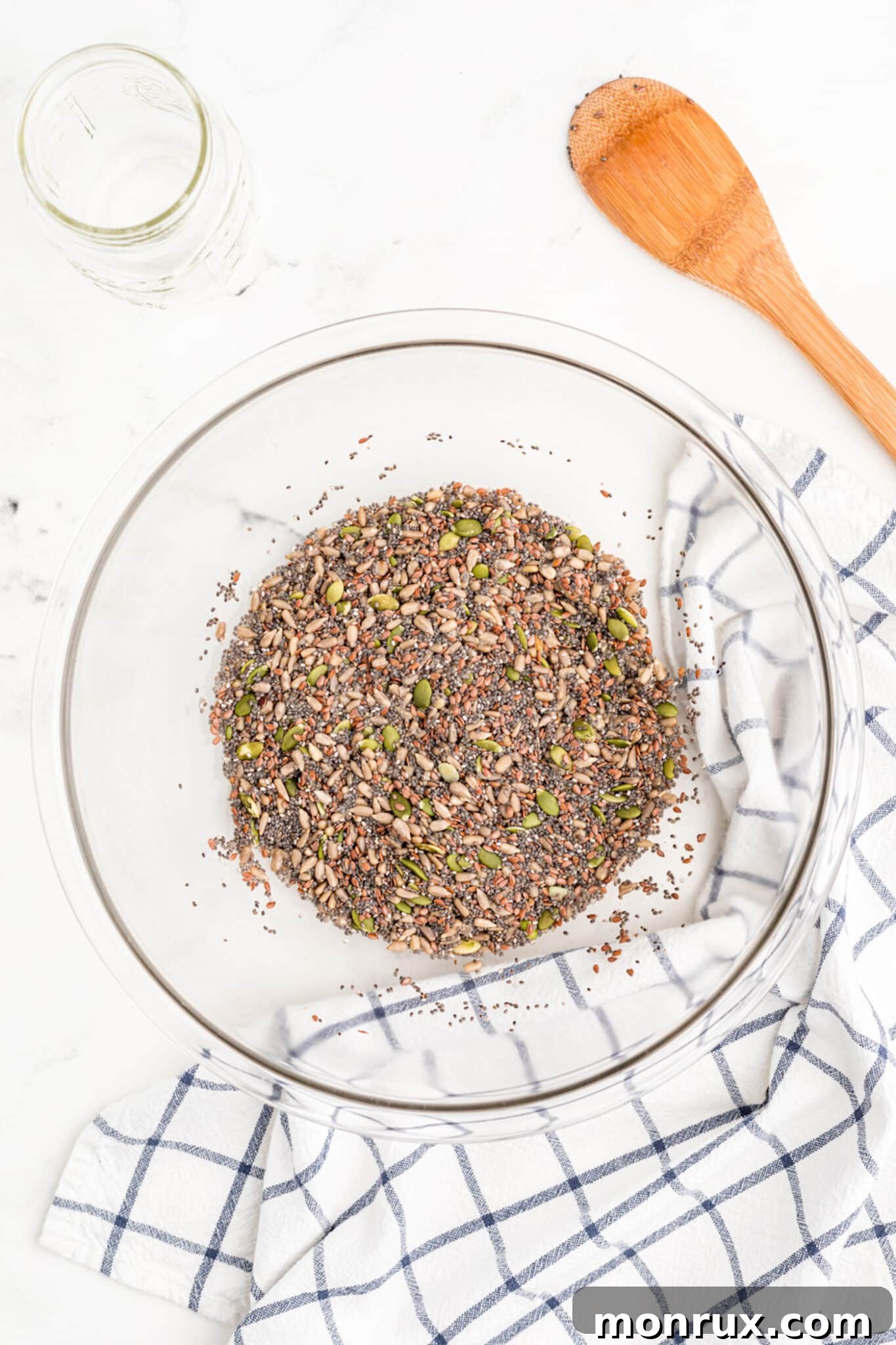 Seed cracker ingredients soaking in water within a bowl, demonstrating the chia seeds beginning to thicken the mixture.