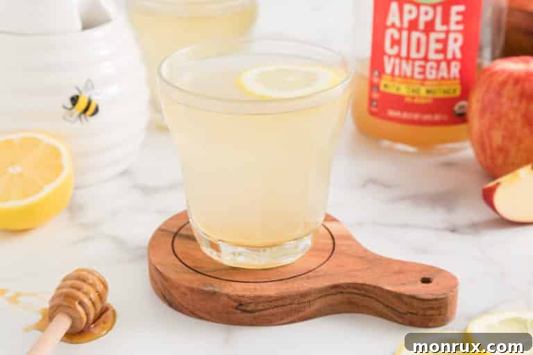 A glass of lemon apple cider vinegar water with a floating lemon wheel.