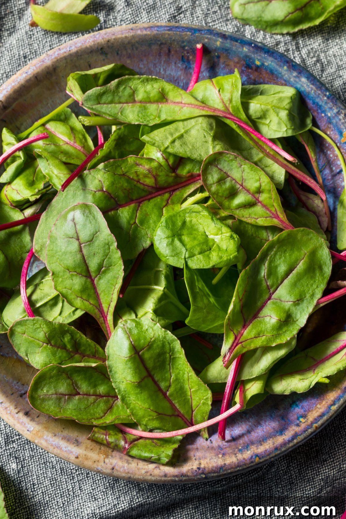 A bowl overflowing with fresh, vibrant beet greens, showcasing their rich color and healthy appearance.