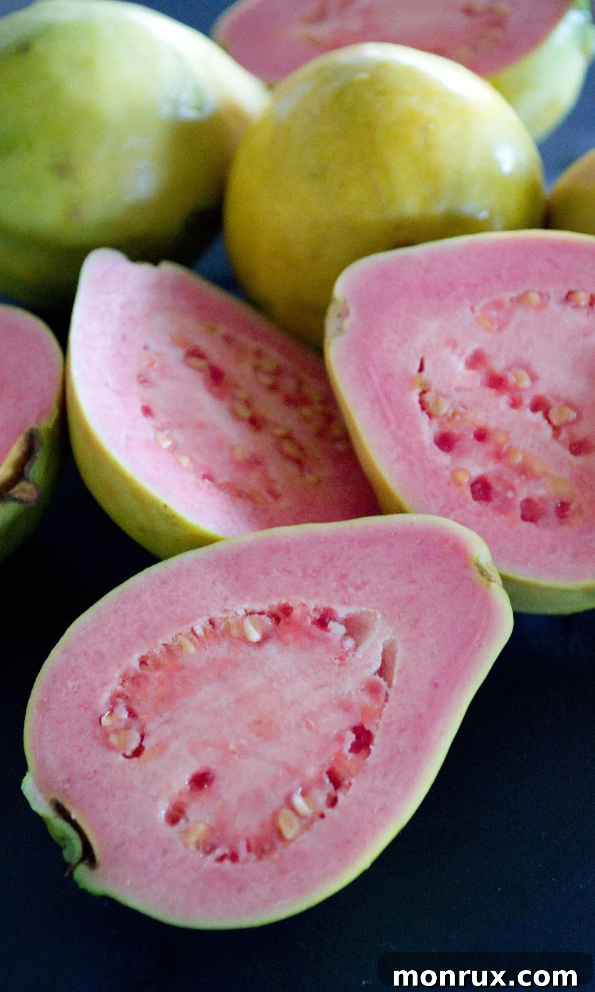 Sliced guava fruit on a plate, showing its pink interior.