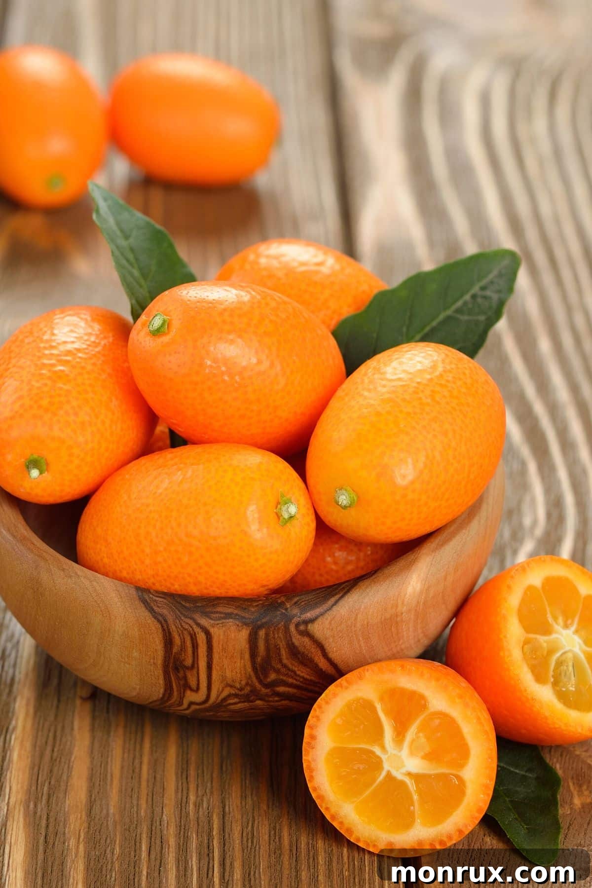 Bright orange kumquats on a tabletop.