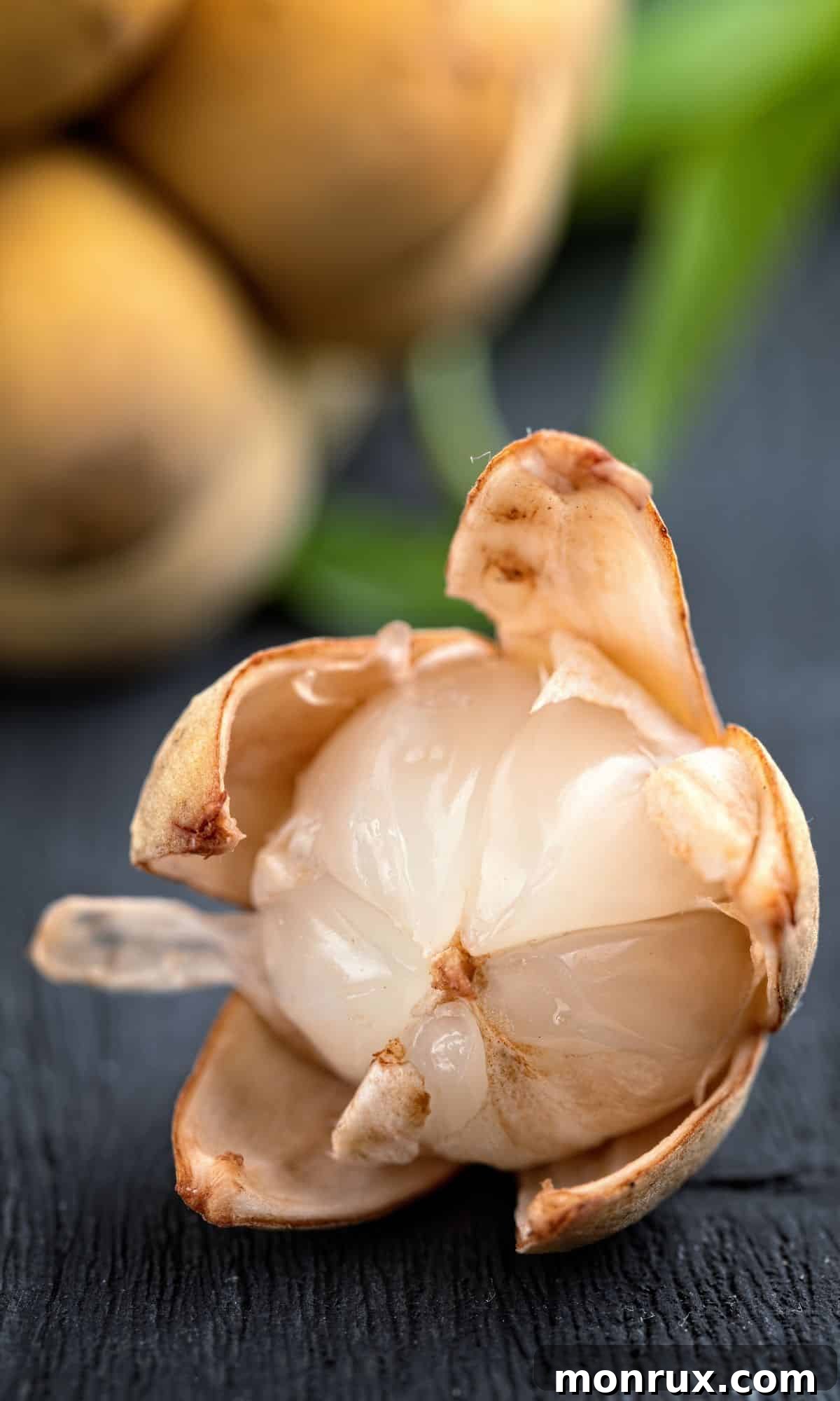 Langsat fruit on a table, peeled to show its translucent segments.