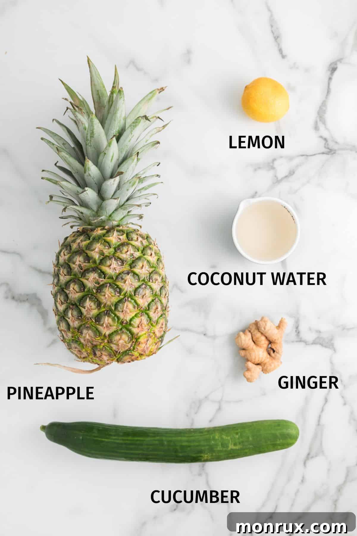 Ingredients for pineapple cucumber juice on a white marble surface.
