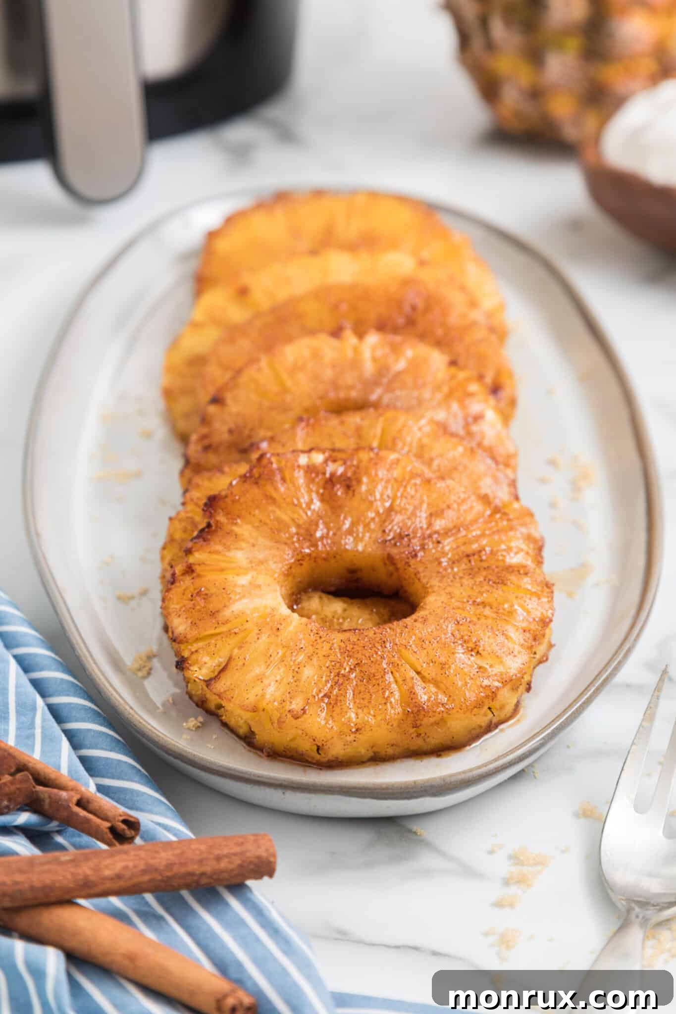 Air fried pineapple rings coated with brown sugar on a long serving platter.