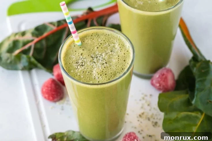 Swiss chard smoothie with strawberries in a glass.