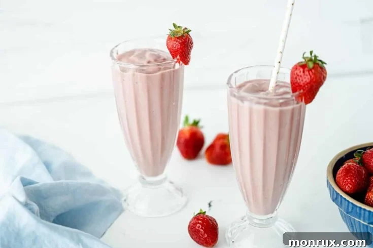Two glasses of vibrant strawberry banana beet smoothie.