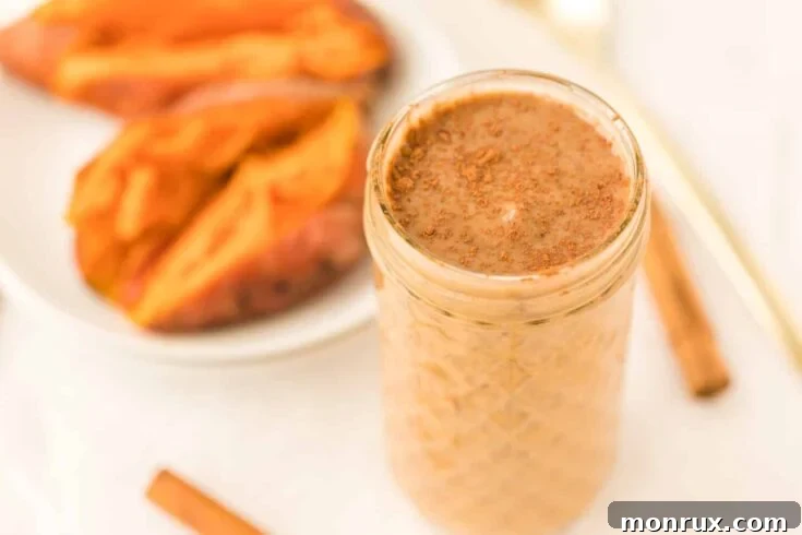Sweet potato smoothie in a glass with a cinnamon stick.