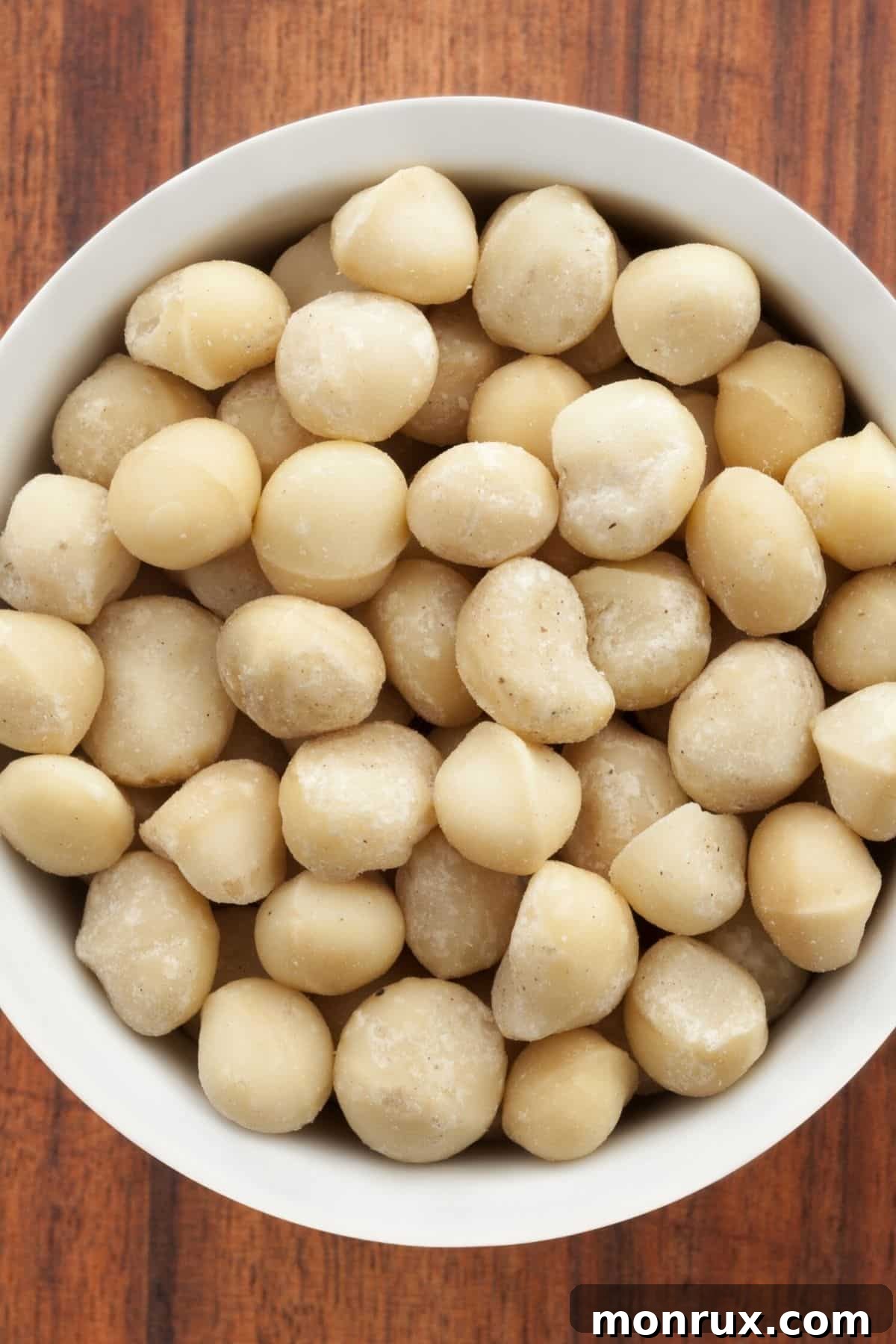 A bowl filled with raw macadamia nuts, ready for milk preparation.