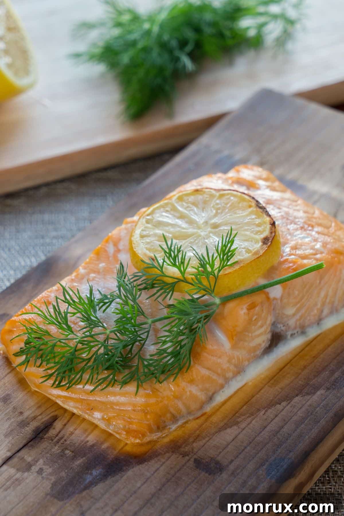 Cooked salmon fillet with lemon slice and fresh dill, showcasing a classic pairing.