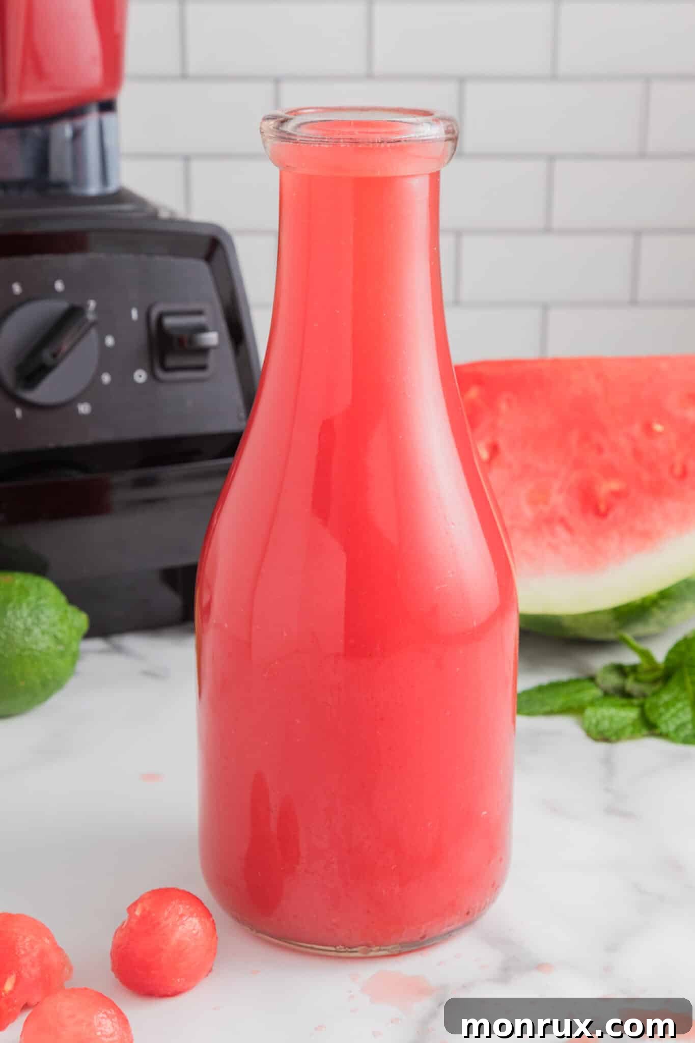 A glass pitcher filled with a vibrant pink watermelon vodka cocktail, ready to be poured and enjoyed.