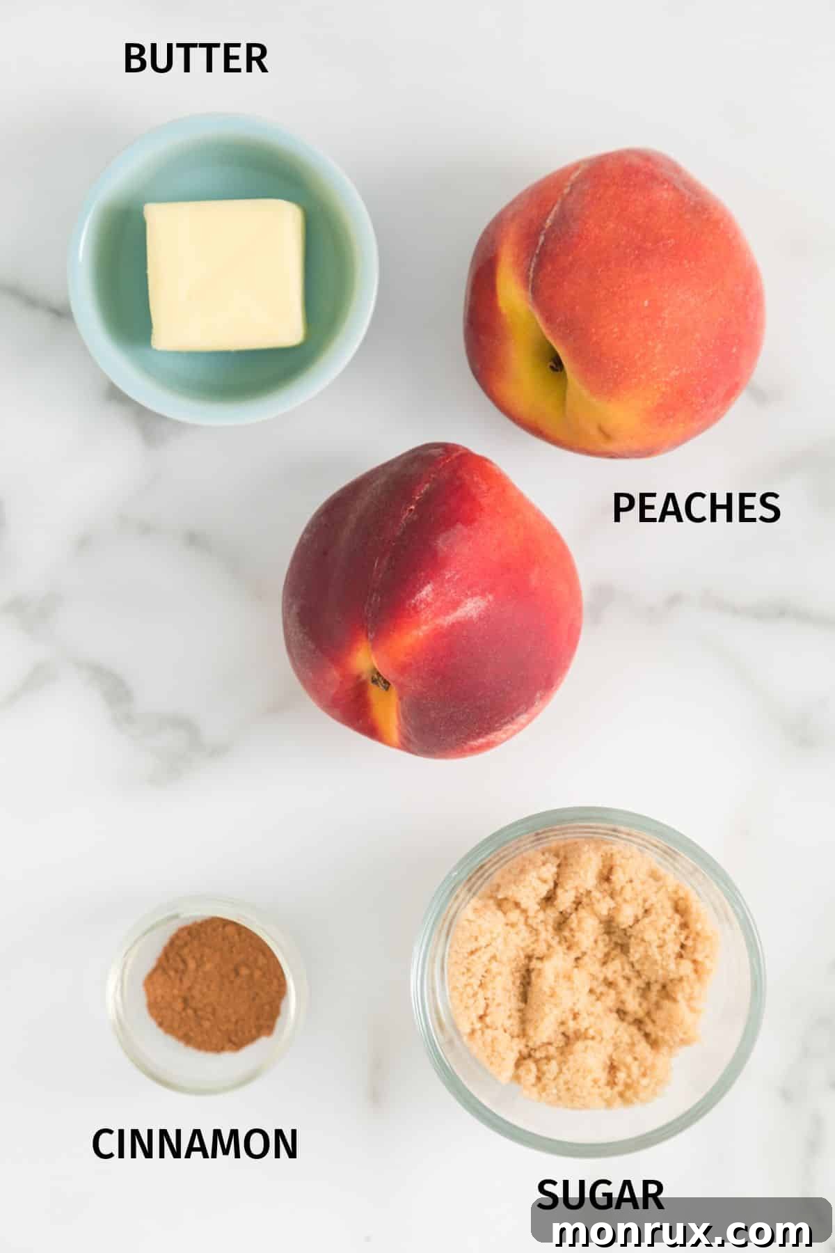 A selection of fresh ingredients laid out on a clean white surface, including ripe peaches, a small bowl of brown sugar and cinnamon mix, and a pat of butter, all ready to create delicious air fryer peaches.