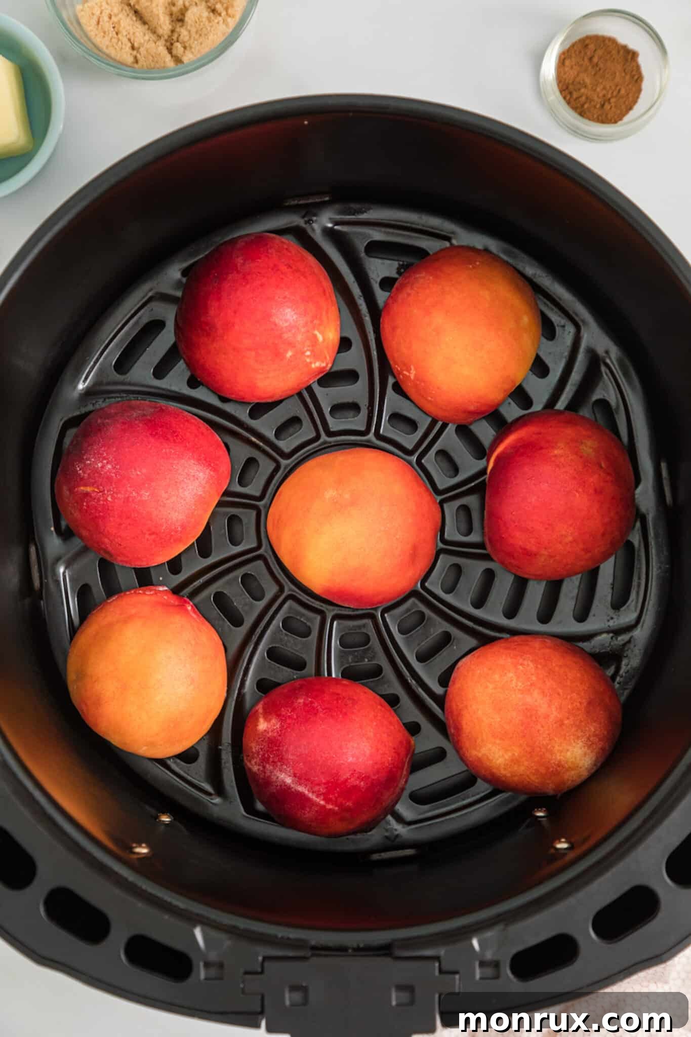 The second step shows peach halves placed neatly with the cut side down in the basket of an air fryer, ready for the initial cooking phase to soften and brown.