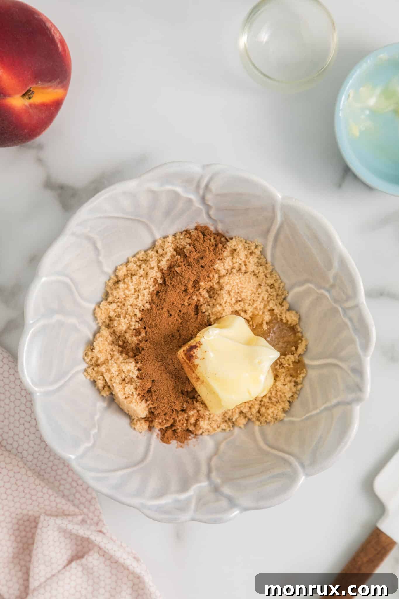 The third step illustrating the preparation of the topping for air fried peaches: a small bowl holds a mixture of softened butter, brown sugar, and cinnamon, ready to be stirred.