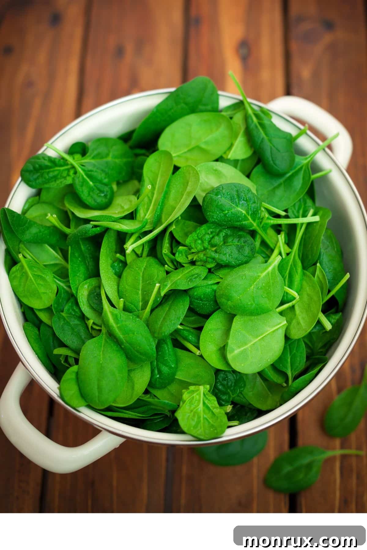A generous bowl of fresh, vibrant spinach leaves, showcasing their crisp texture and deep green color.