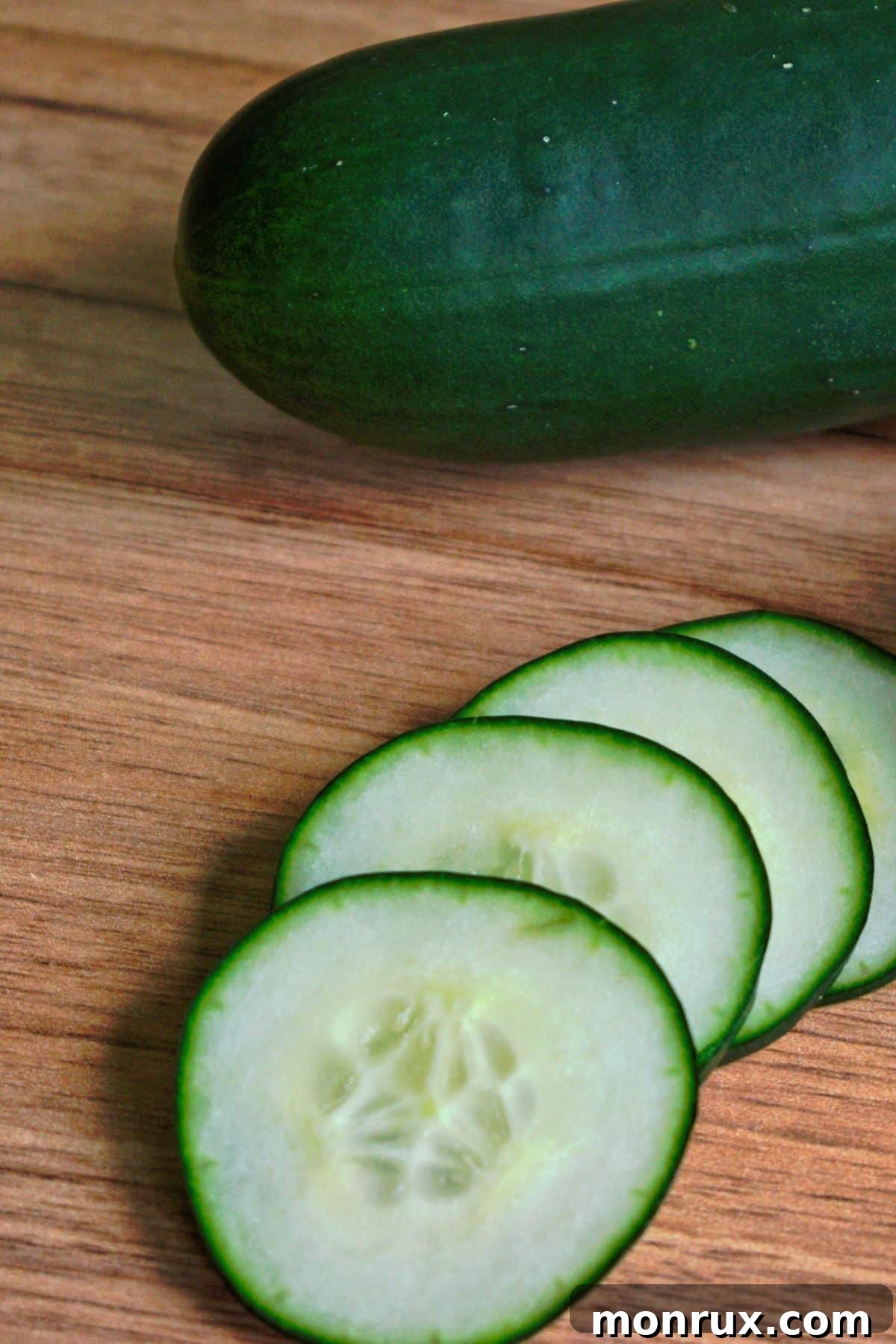A fresh, green cucumber on a wooden table, emphasizing its hydrating qualities.