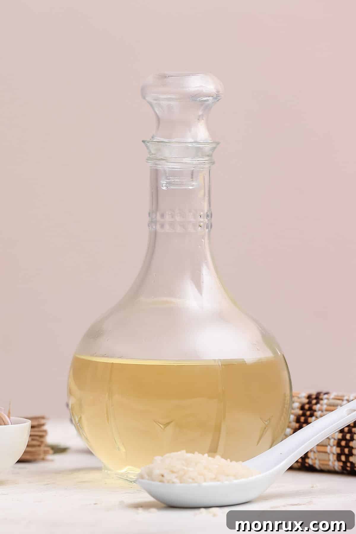 Bottle of rice wine vinegar with scoop of rice.