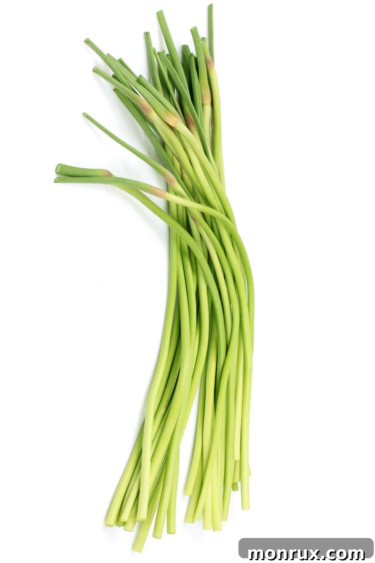 A bundled stack of fresh green garlic scapes, with vibrant green stems and subtle white bases, a seasonal delight.