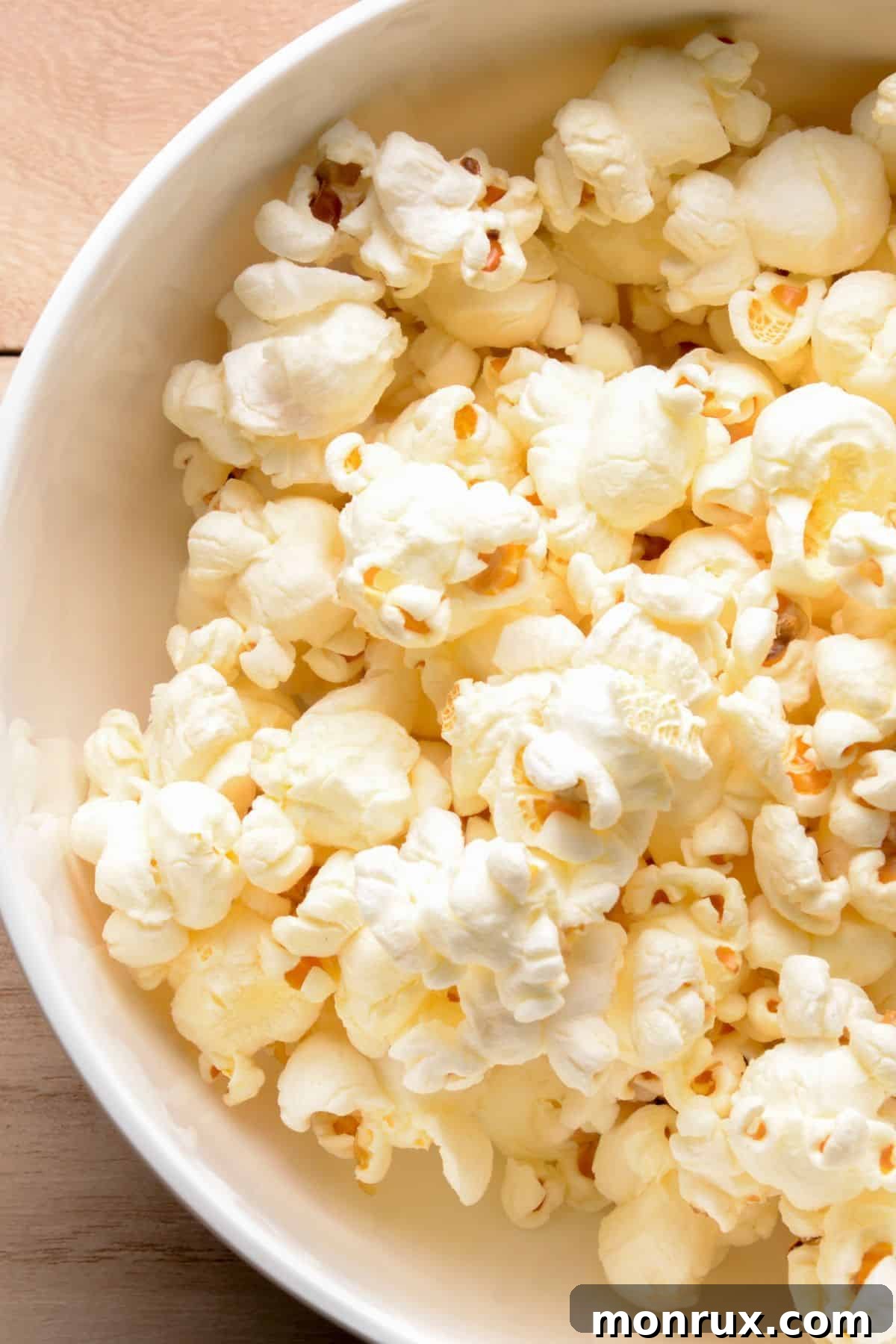 Freshly popped popcorn in a simple white ceramic bowl, ready for snacking.