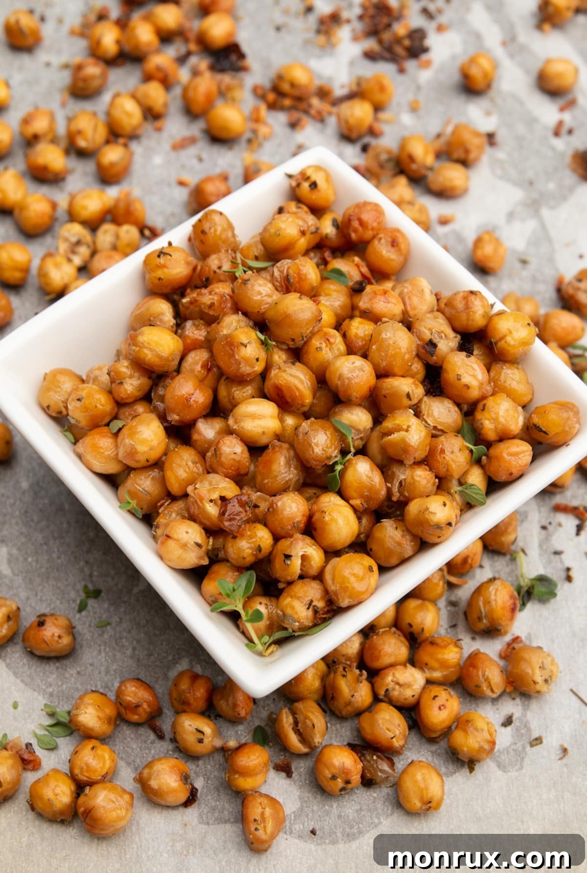 A white serving bowl filled with golden, crispy garlic roasted chickpeas.